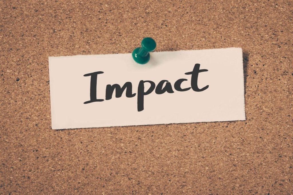 Note reading 'Impact' pinned to a cork board